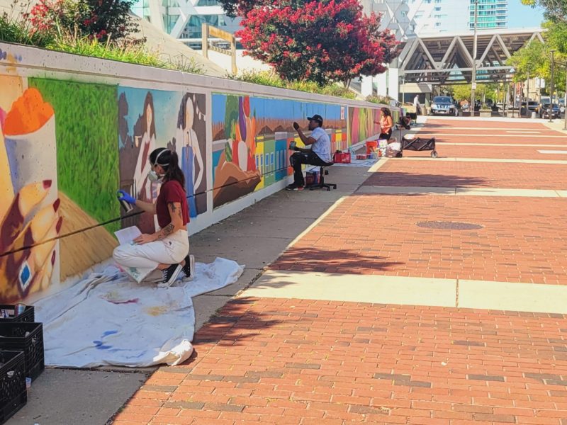 Artists paint murals at the Baltimore Convention Center as part of BRUSH Mural Fest. Photo by Ed Gunts.