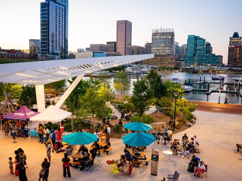 photo of concert being held at Rash Field at sunset with view of Inner Harbor skyline in background