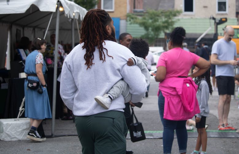 Jacari Johnson and his son browse the Baltimore Book Festival on Sept. 29, 2024. Photo by Maggie Jones.