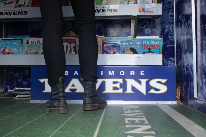 Rachel Plumly browses the Baltimore Ravens Bookmobile, which gives out free books to low-income children, at the Baltimore Book Festival on Sept. 29, 2024. Photo by Maggie Jones.