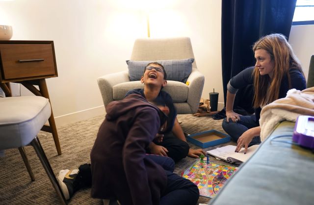 Therapist Sarah Sutton, right, looks on as brothers Ronan Kotiya, 11, left, and Keaton Kotiya, 9, center, laugh during a counseling session in Plano, Texas, Friday, April 8, 2022. LM Otero/AP.