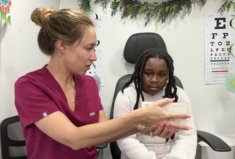 Vision to Learn optometrist Arianna Jordan gives 10-year-old Chloe Bryson a free eye exam. Photo by John Lee/WYPR.