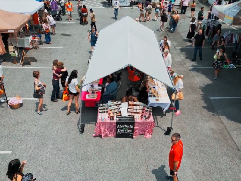 Vendors and customers mill about the Rosebud Flea Market in Towson. Screenshot via drone footage.