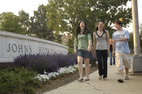 Students walk by the main gate to the Homewood campus of The Johns Hopkins University in north Baltimore. Photo courtesy of Homewood Photography/JHU.