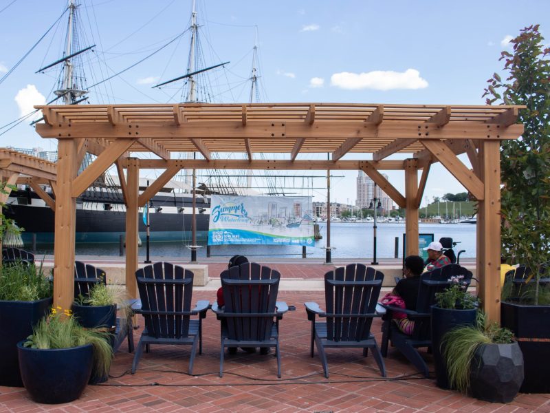 Baltimore residents enjoy the new shade stations located in Baltimore's Inner Harbor in May 2024. Photo by Maggie Jones.