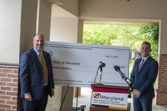 (Left) Matthew Heckles, regional administrator for the U.S. Department of Housing and Urban Development, and (right) Maryland Department of Housing and Community Development Secretary Jake Day pose in front of a check for $2 million to support Maryland's homeless youth. Photo courtesy of Maryland Department of Housing and Community Development.