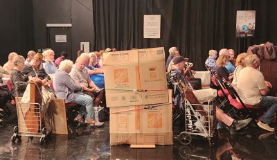 group sitting in chairs in rows inside a tv studio