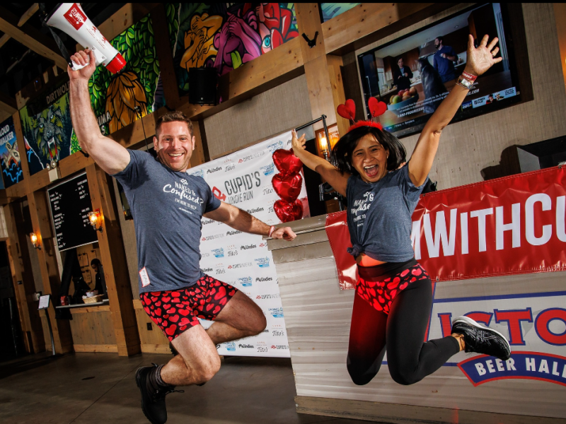 two people jumping in the air with red underwear and grey tshirts, arms in the air