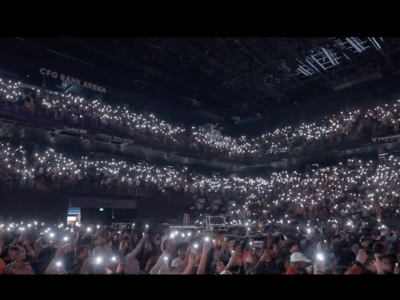 dark concert hall with attendees holding up flashlights