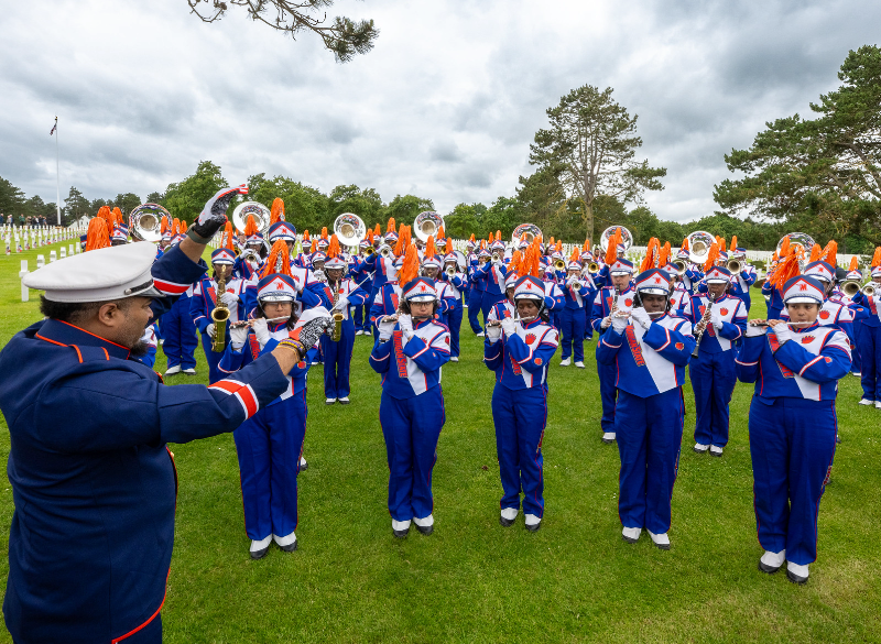 marching band with conductor in formation at a cemetery