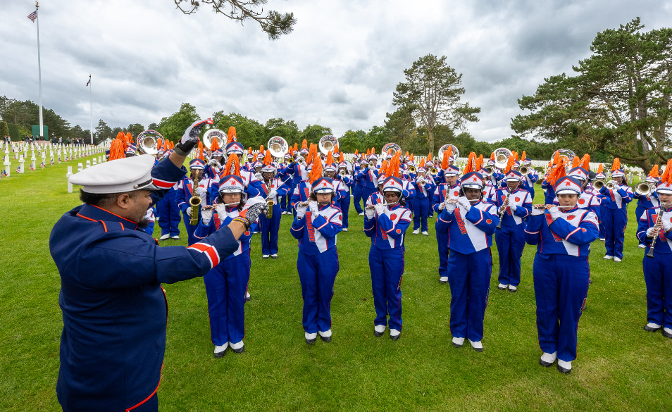 marching band with conductor in formation at a cemetery