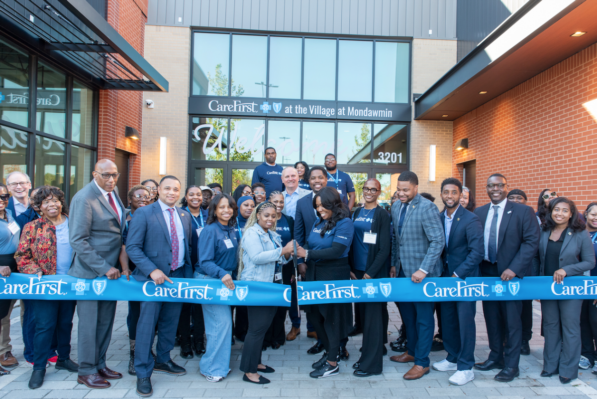 group of people at ribbon cutting ceremony in front of building with glass front